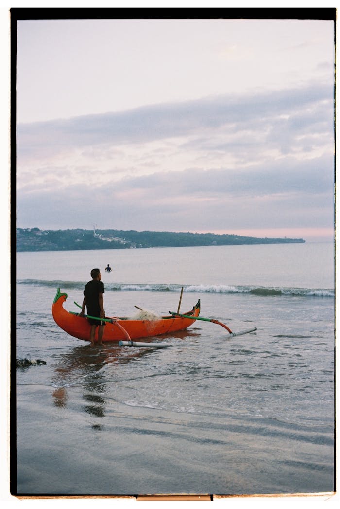 Man Standing with Boat on Sea Shore